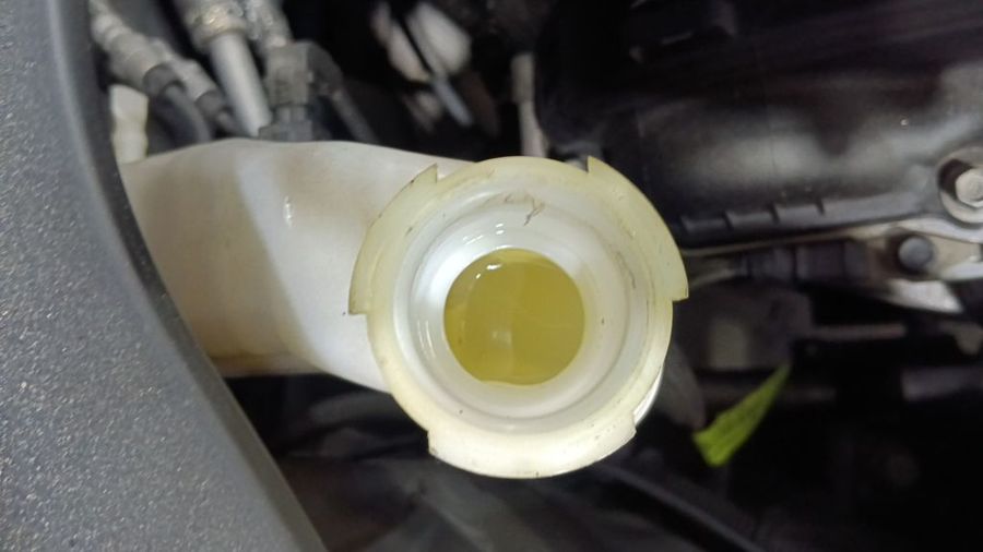 Kia Sportage coolant reservoir showing discoloured yellow coolant that needed topping up