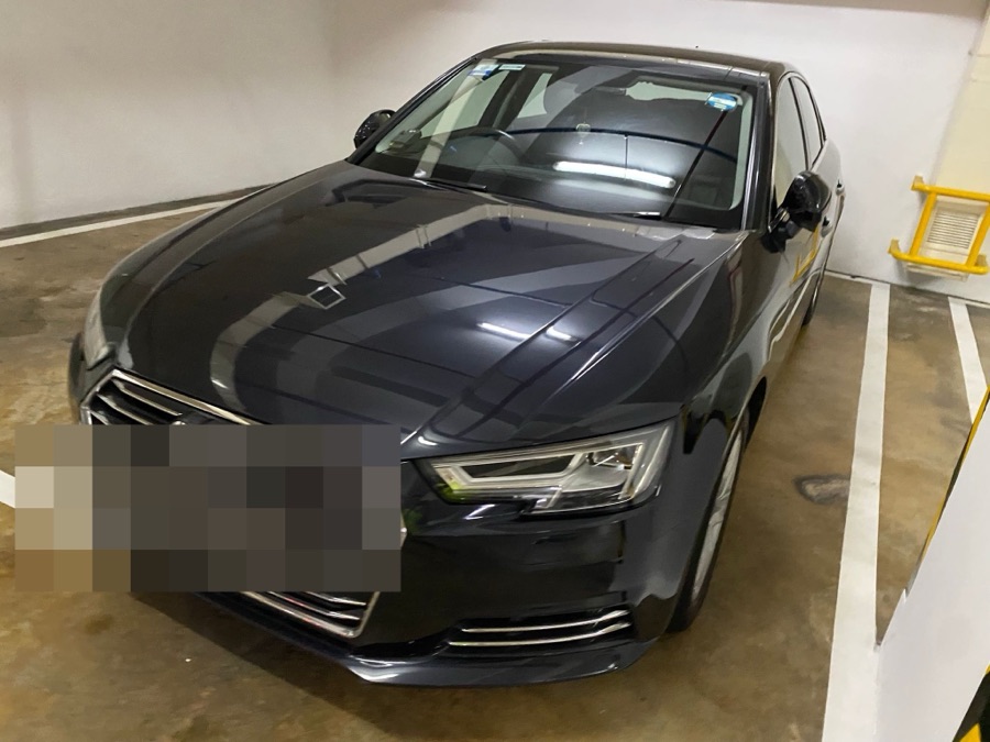 Dark grey Audi A4 in a basement car park before servicing.