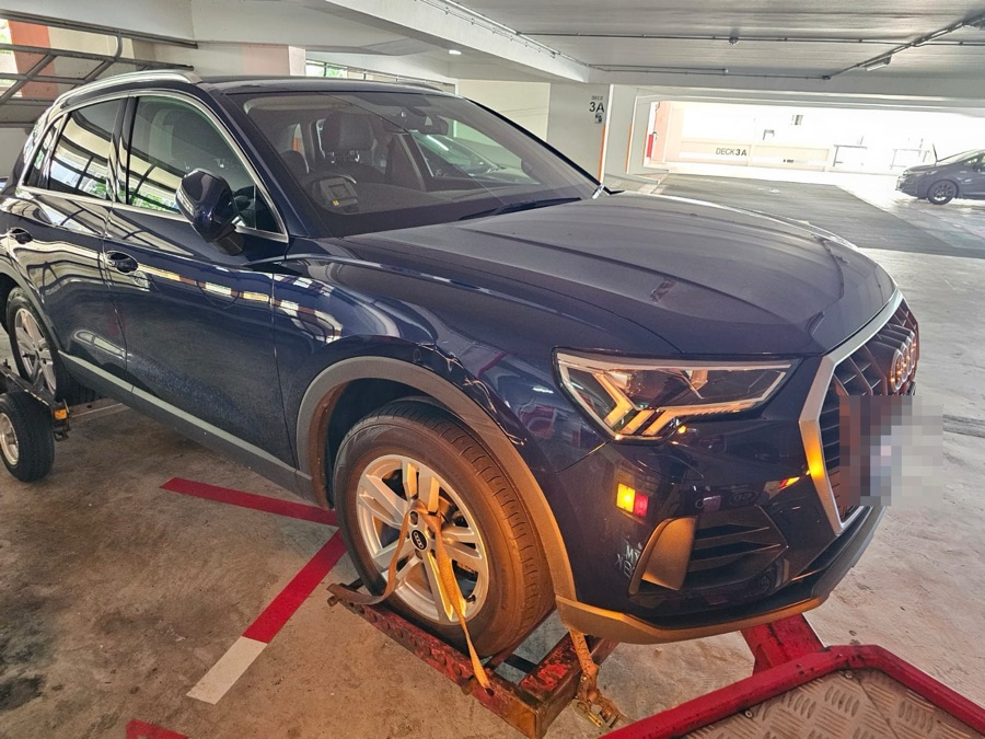 Audi Q3 front view, collected by tow truck for servicing.