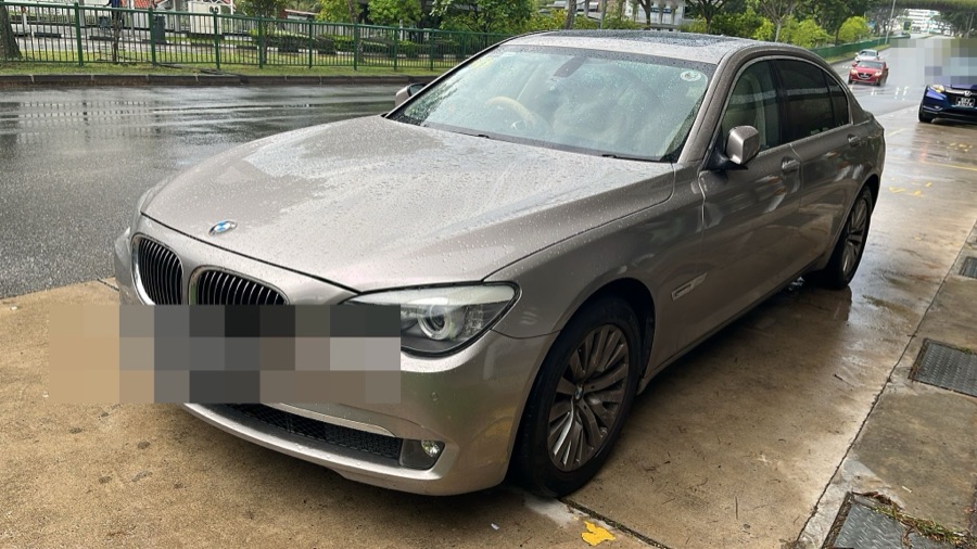 BMW 7 Series parked roadside, collected by tow truck for servicing.