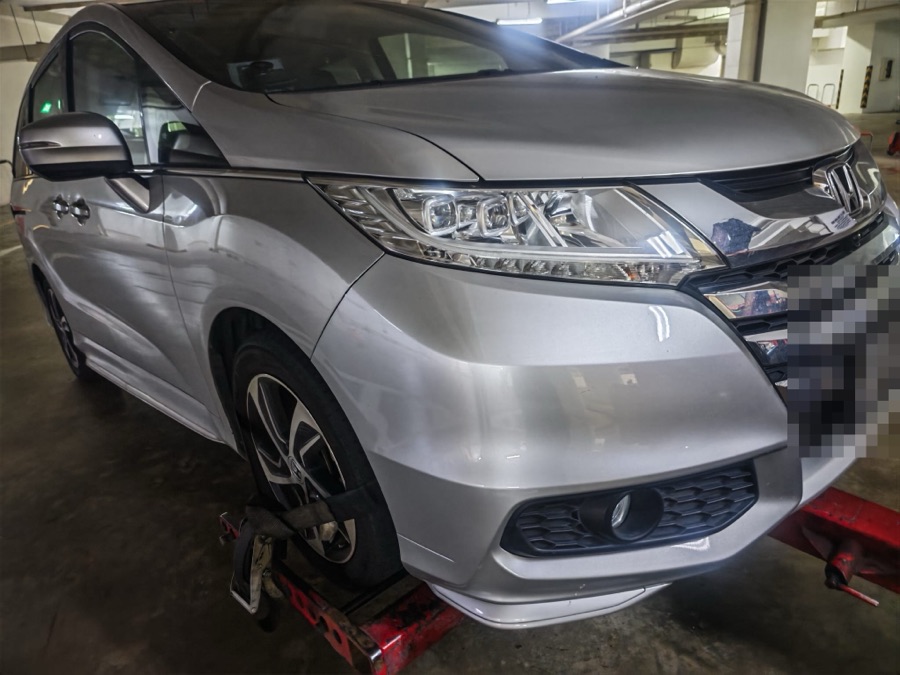 Honda Odyssey MPV being transported on a tow dolly indoors