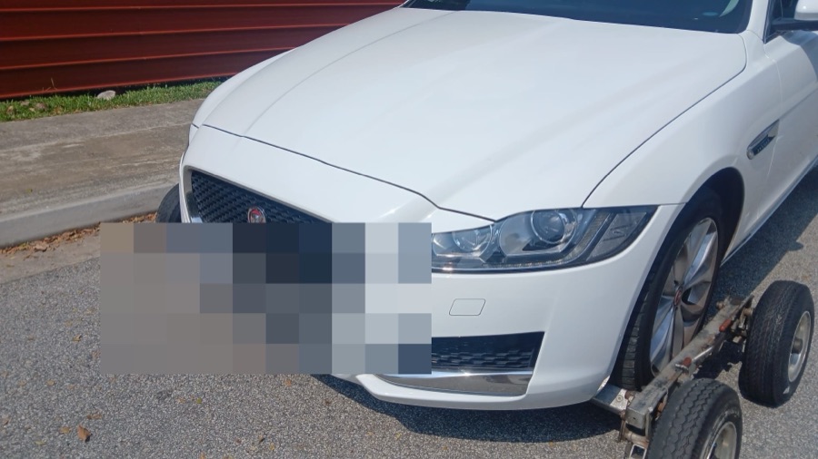 Jaguar XF sedan being transported on a tow dolly indoors