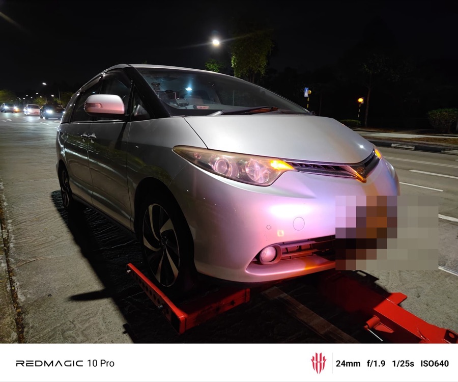 Toyota Estima MPV being towed in for workshop service at night