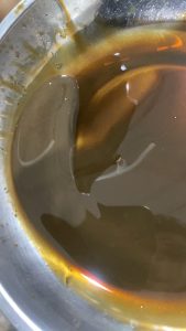 BMW Transmission Issue: The Impact of a Leaking Auto Cooler - 1 Car Service Workshop - Gearbox, Aircon and Engine Specialist Milky transmission fluid in a drain pan from a BMW due to a leaking auto cooler